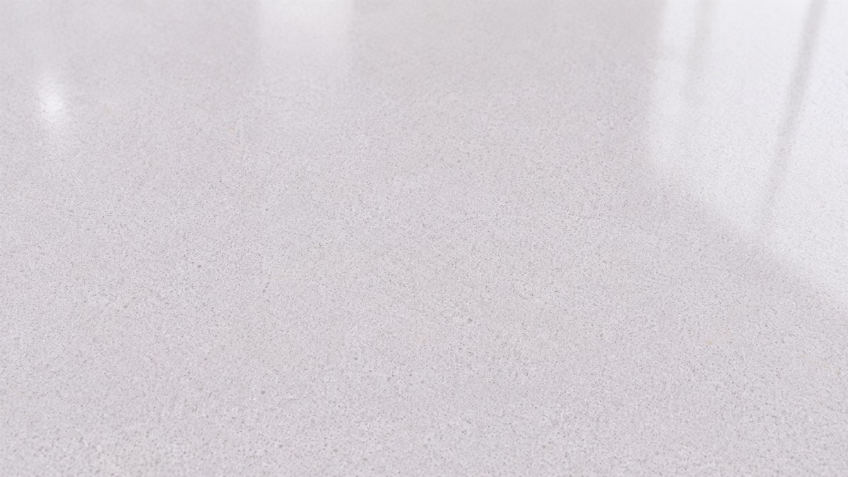 Polished surface detail of soft white artificial marble with subtle granular texture