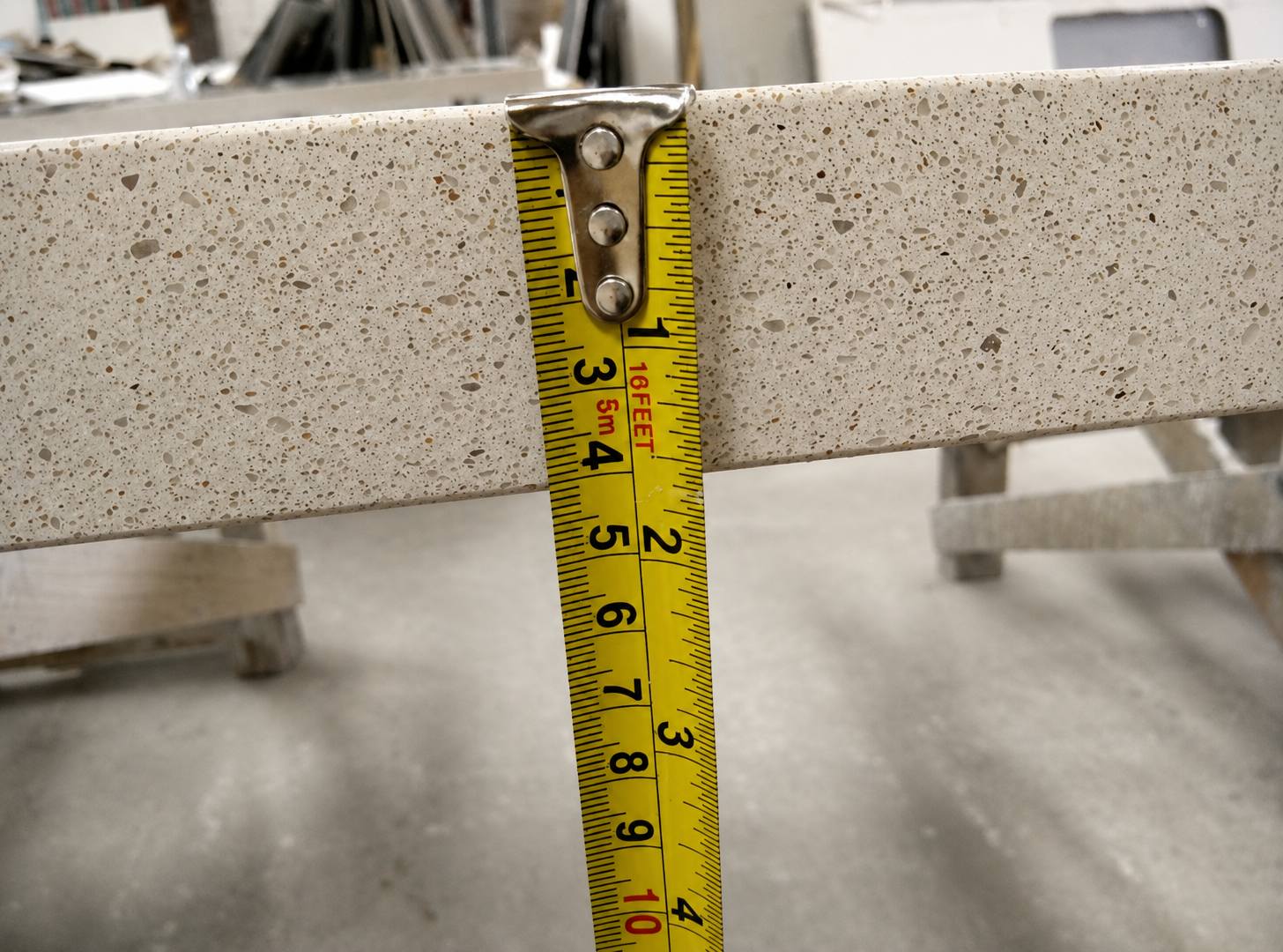 Warm beige quartz countertop with fine speckled texture and polished edge for multifamily countertop