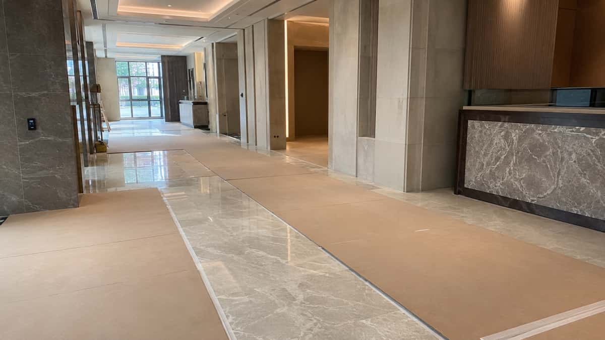 Installed stone floor protected before project handover in a clean commercial interior