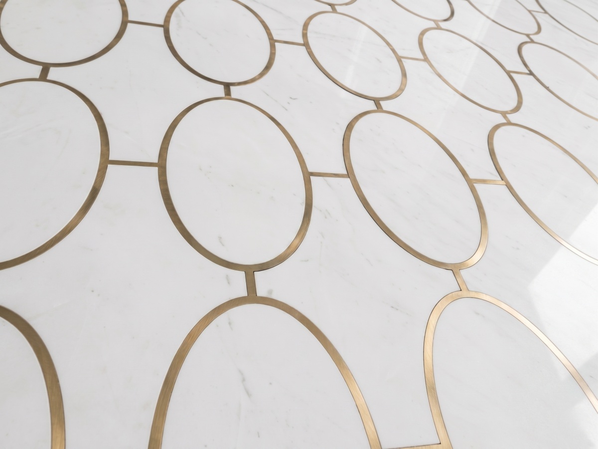 white-marble-brass-inlay-flooring-close-up Close-up of white marble flooring with subtle grey veining and brass-colored inlay for a casino project