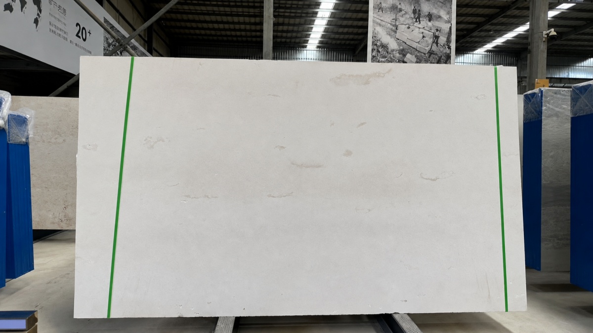 Natural white limestone slab on a support rack in a stone factory 